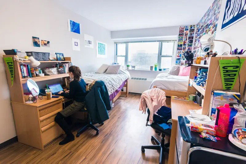 (Photo: Isabel Epstein) Students sitting in their dorm room inside Carman Hall that is filled with decorations.