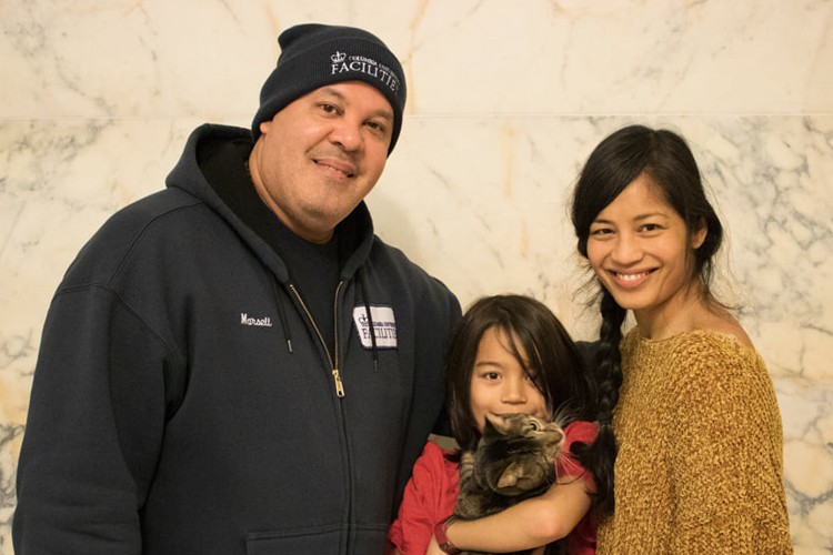 Marcel, the Columbia Residential employee who helped saved the kitten, standing with Professor Cruz and her son, who is holding the kitten.