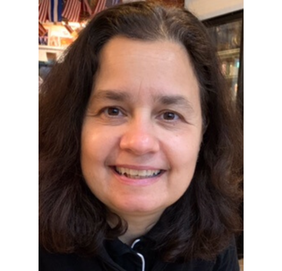 A woman with dark hair and brown eyes smiles and looks into the camera