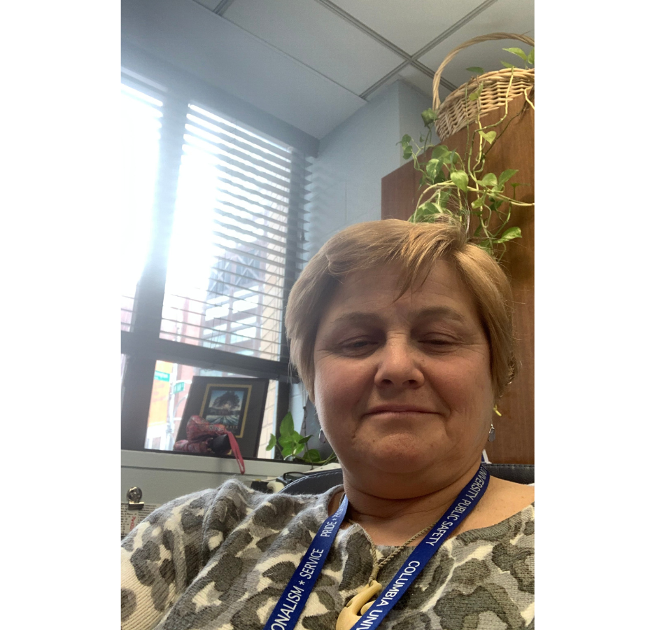 A person sitting in an office, smiling at the camera