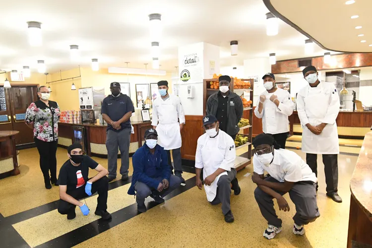 A group of Columbia Dining employees gather together inside John Jay Dining Hall.