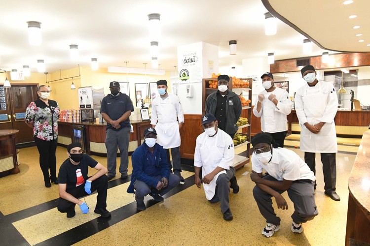 A group of Columbia Dining employees gather together inside John Jay Dining Hall.