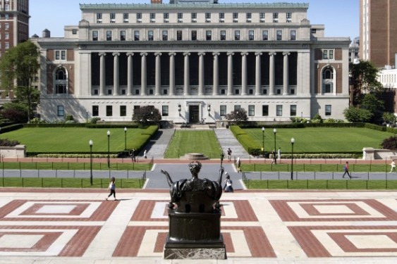 A view behind alma mater looking out onto College Walk and Butler Library on a sunny day.